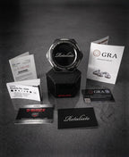A jewelry service kit featuring a central black hexagonal display stand with the word 'Retaliate' on it, surrounded by branded business cards, a CASIO G-Shock watch, a diamond report card, and informational brochures on a dark textured background.